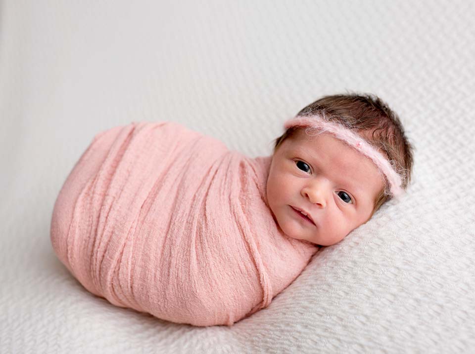 Baby girl in Jelly bean wrap pose by newborn photographer Kelly Rawlinson