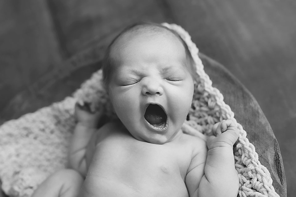 Black and white photo of baby girl yawning