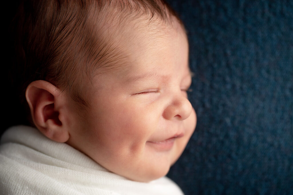 Pro photo of smiling newborn boy with big dimples